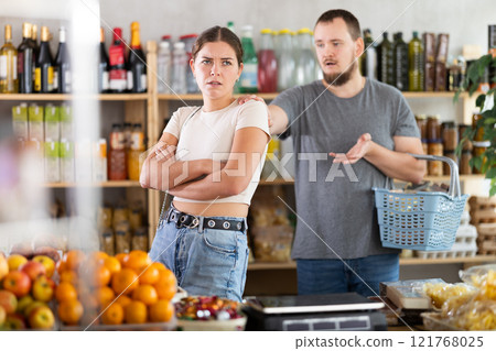 Husband calms his wife down after an argument in grocery supermarket, apologizing 121768025
