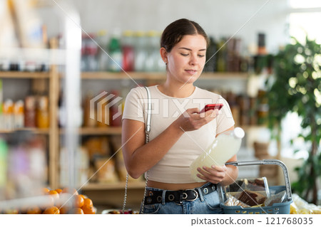 Young woman scanning qr code of soda 121768035