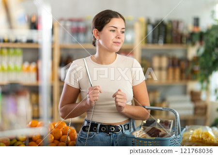 Young woman choosing food in grocery store 121768036