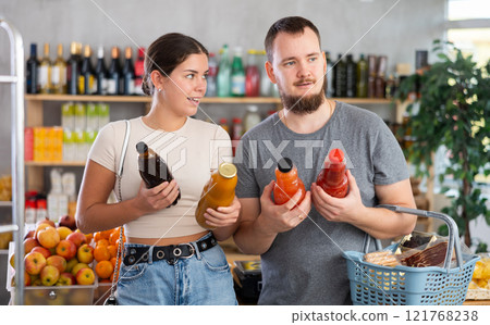 Couple choosing juices in the supermarket Couple choosing juices in the supermarket 121768238