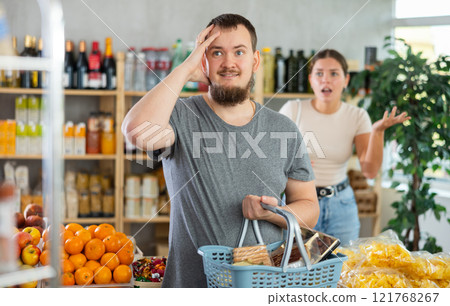 man is quarreling with his wife in a store. man is quarreling with his wife in a store. 121768267
