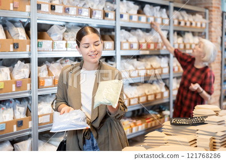 Young woman chooses pack of dry clay 121768286