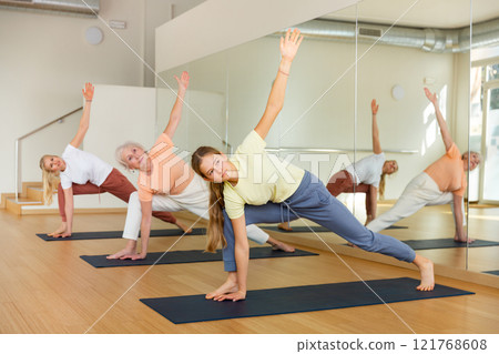 Women exercising yoga poses in fitness gym. Extended triangle pose 121768608