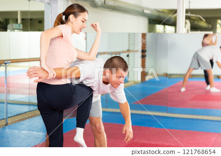 Woman learning knee strike move during self-defense training Woman learning knee strike move during self-defense training 121768654