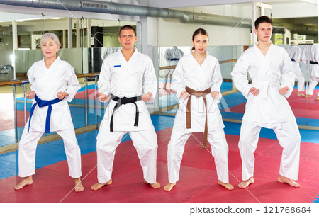 People in kimonos practicing punches during group martial arts workout People in kimonos practicing punches during group martial arts workout 121768684
