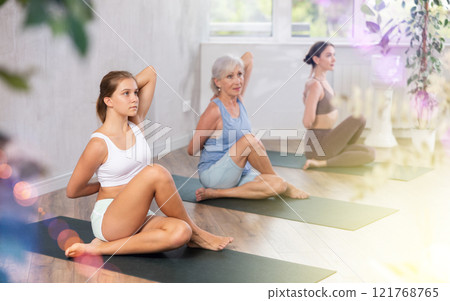 Teenage girl doing yoga in group in studio Teenage girl doing yoga in group in studio 121768765