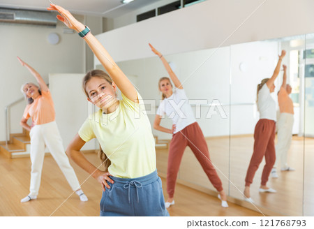 Teenage girl doing bending sideways with her family during fitness training Teenage girl doing bending sideways with her family during fitness training 121768793