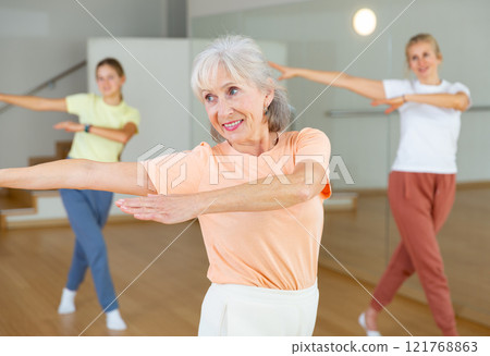 Mature female dancing with other women 121768863