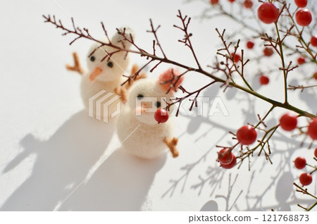 Red Nandina berries and a wool felt snowman Red Nandina berries and a wool felt snowman 121768873