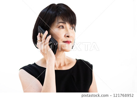 A woman with black bob hair talking on a smartphone 121768952