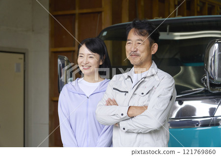 Portrait of a worker couple standing in front of a truck Portrait of a worker couple standing in front of a truck 121769860