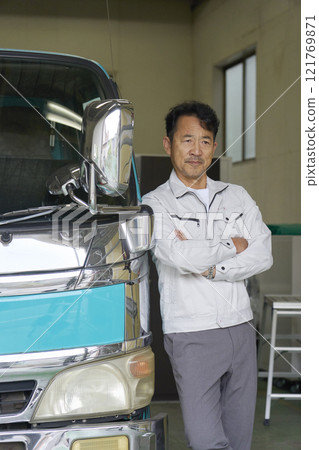 一名穿著工作服的男子站在卡車旁的肖像 121769871