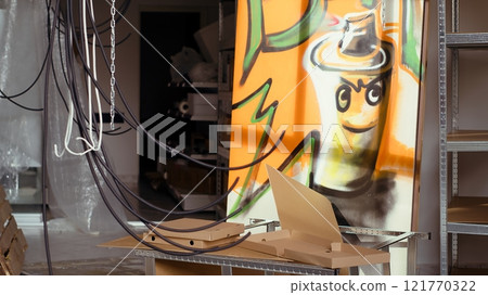 Close up of empty pizza boxes in industrial warehouse with graffiti drawings on walls. Trash left over in underground location used as crime haven by delinquents, urban background Close up of empty pizza boxes in industrial warehouse with graffiti drawings on walls. Trash left over in underground location used as crime haven by delinquents, urban background 121770322