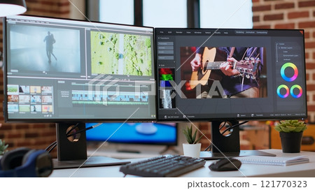 Empty video editing tools and a color wheel running on pc at desk, timeline editing, color grading and media creation for a video shoot. Post production software on dual monitors. 121770323