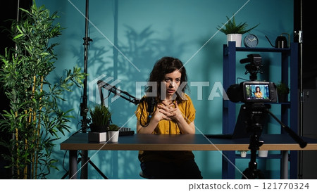 Content creator using professional camera to shoot intro for vlog channel on online platforms. Internet star warmly welcoming dedicated fanbase, recording with advanced gear, camera B Content creator using professional camera to shoot intro for vlog channel on online platforms. Internet star warmly welcoming dedicated fanbase, recording with advanced gear, camera B 121770324