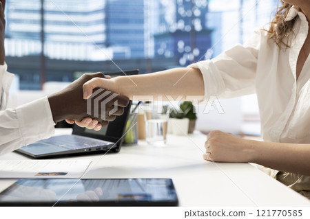 HR employee does welcoming handshake after determining candidate possesses skills needed to fulfil role. Close up of HR manager shaking hands after evaluating applicant qualifications HR employee does welcoming handshake after determining candidate possesses skills needed to fulfil role. Close up of HR manager shaking hands after evaluating applicant qualifications 121770585