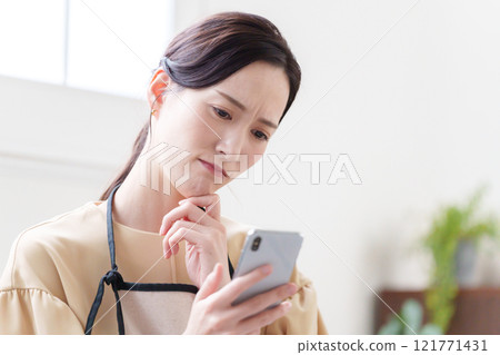 看智慧型手機的家庭主婦婦女人 121771431