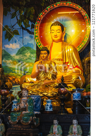 An altar with a golden Buddha in a pagoda on the marble mountains of Da Nang. 121771620