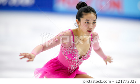 Asian female figure skater gliding on ice, performing graceful routine, focused expression, elegance in motion, professional athlete at winter competition, poised and artistic, ice rink 121772322