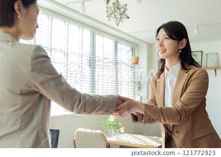 Two businesswomen shaking hands 121772923