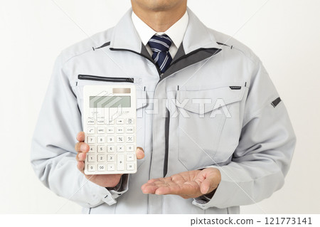 A man wearing work clothes and holding a calculator on a white background 121773141