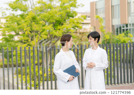 Smiling women in white coats 121774396