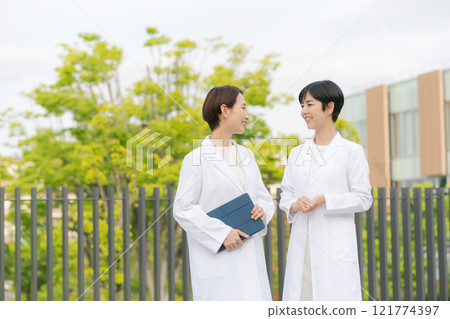 身穿白大褂的婦女微笑著交談 121774397