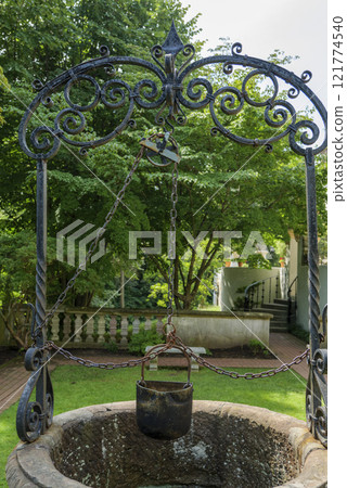 old well with a bucket and forged frame at Vanderbilt Museum Long Island New York 121774540