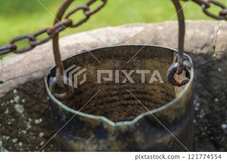 Old well bucket with rusty chain, life concept from a century ago. Old well bucket with rusty chain, life concept from a century ago. 121774554