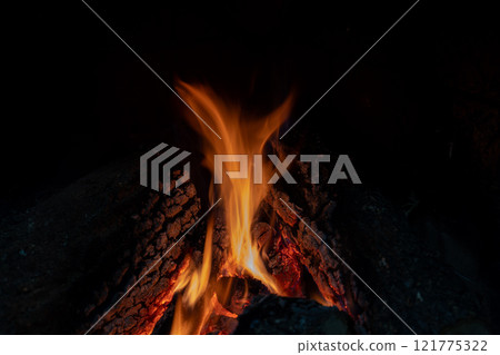 Glowing campfire flames in a dark night 121775322