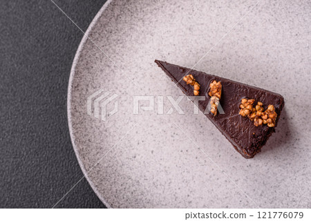 Piece of sweet chocolate cake with nuts 121776079