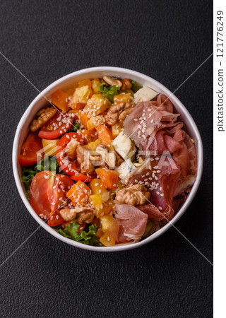 Appetizing salad with prosciutto, pumpkin, cheese and tomatoes 121776249