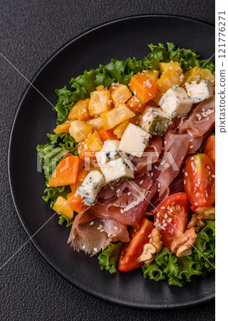 Appetizing salad with prosciutto, pumpkin, cheese and tomatoes 121776271