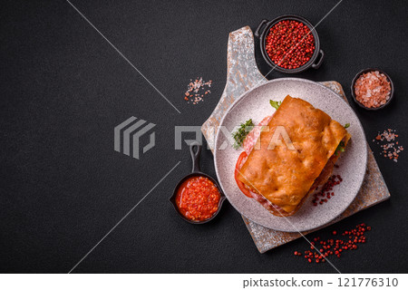 Focaccia with salami, cheese, tomatoes, arugula, salt, spices and herbs 121776310