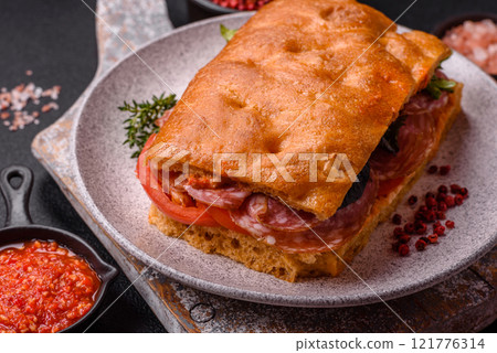 Focaccia with salami, cheese, tomatoes, arugula, salt, spices and herbs Focaccia with salami, cheese, tomatoes, arugula, salt, spices and herbs 121776314