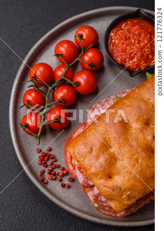Focaccia with salami, cheese, tomatoes, arugula, salt, spices and herbs 121776324
