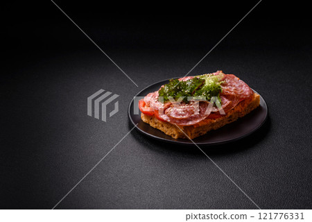 Focaccia with salami, cheese, tomatoes, arugula, salt, spices and herbs Focaccia with salami, cheese, tomatoes, arugula, salt, spices and herbs 121776331