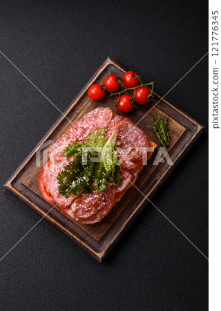Focaccia with salami, cheese, tomatoes, arugula, salt, spices and herbs Focaccia with salami, cheese, tomatoes, arugula, salt, spices and herbs 121776345