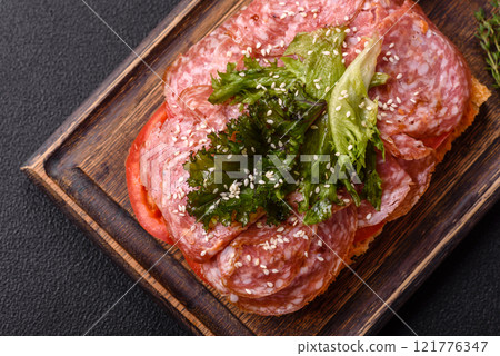 Focaccia with salami, cheese, tomatoes, arugula, salt, spices and herbs Focaccia with salami, cheese, tomatoes, arugula, salt, spices and herbs 121776347