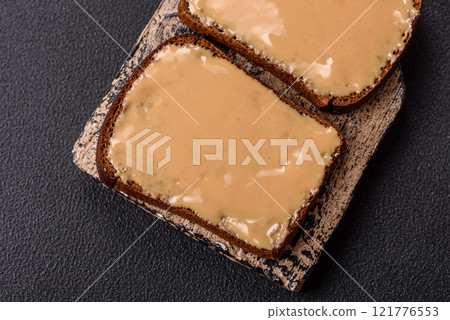 Sandwiches with toast bread, peanut butter and raspberry or strawberry jam 121776553