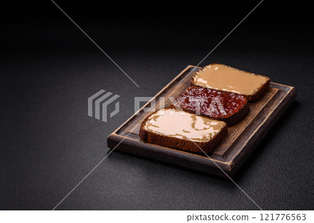 Sandwiches with toast bread, peanut butter and raspberry or strawberry jam 121776563