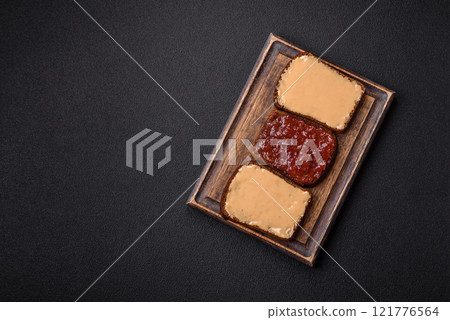 Sandwiches with toast bread, peanut butter and raspberry or strawberry jam 121776564
