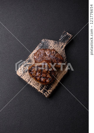 Juicy beef steak baked on the grill with salt, spices and herbs Juicy beef steak baked on the grill with salt, spices and herbs 121776654