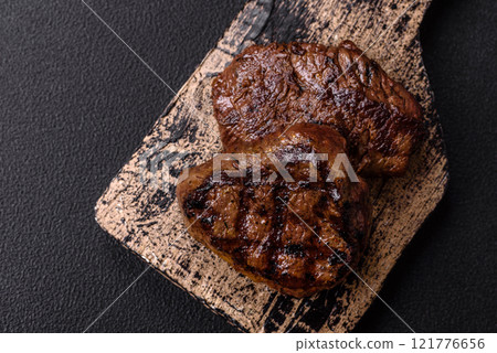 Juicy beef steak baked on the grill with salt, spices and herbs 121776656