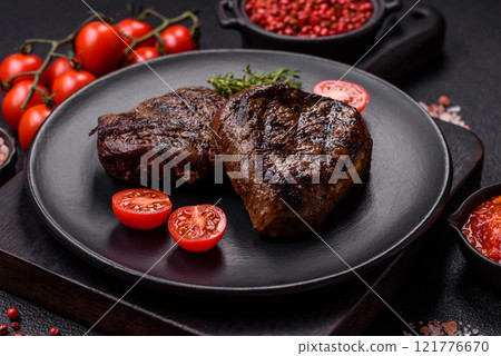 Juicy beef steak baked on the grill with salt, spices and herbs Juicy beef steak baked on the grill with salt, spices and herbs 121776670