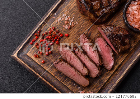 Juicy beef steak baked on the grill with salt, spices and herbs 121776692