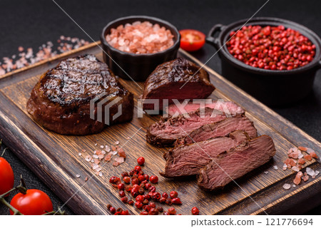 Juicy beef steak baked on the grill with salt, spices and herbs Juicy beef steak baked on the grill with salt, spices and herbs 121776694