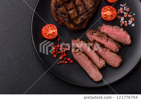 Juicy beef steak baked on the grill with salt, spices and herbs 121776704