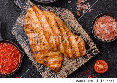Juicy chicken fillet baked on the grill with salt, spices and herbs 121776731