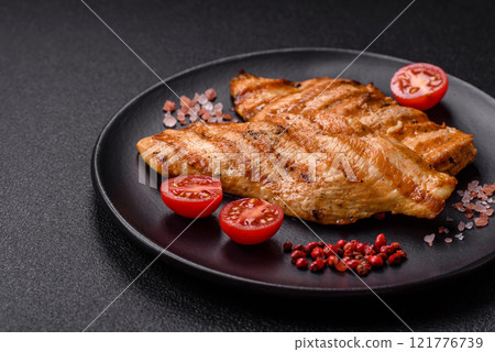Juicy chicken fillet baked on the grill with salt, spices and herbs Juicy chicken fillet baked on the grill with salt, spices and herbs 121776739